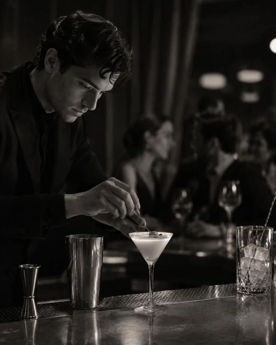 Bartender garnishing a martini-style cocktail at the polished Amanti bar